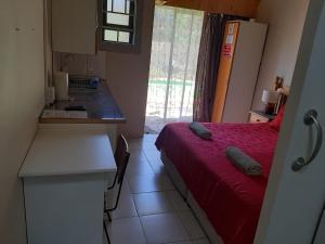 a bedroom with a bed and a kitchen with a counter at Chariots Guest House in Polokwane