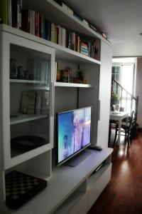 un soggiorno con TV su una mensola bianca di Casa Thomas a Sanremo