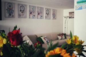 un soggiorno con divano e alcuni fiori di Casa Thomas a Sanremo