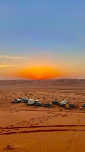 a group of houses in the desert at sunset at SandGlass Camp in Bidiyah