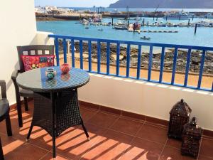 a balcony with a table and a view of a harbor at Suite Marrakech Beach, La Graciosa. in Caleta de Sebo