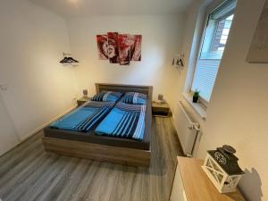una camera da letto con un letto con lenzuola blu e una finestra di LaPurka I a Nordhorn