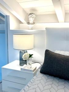 a bedroom with a bed and a nightstand with a lamp at PAGANINI suits and apartments in Sirmione