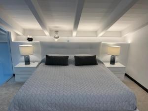 a bedroom with a bed with two pillows and two lamps at PAGANINI suits and apartments in Sirmione