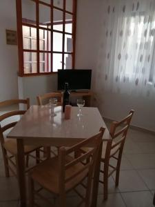 a dining room table with a bottle of wine and chairs at Apartments Stipanovic in Biograd na Moru