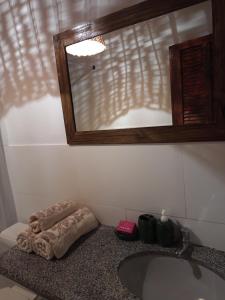 a bathroom with a sink and a mirror at Loft 01 encanto dos ipês in Paraty +36 photos