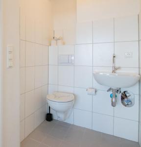 Un baño blanco con inodoro y lavabo. en T&K Apartments Comfortable 3 Room Apartments with Balcony, en Duisburg