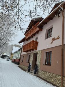 a building with a balcony on top of it in the snow at Penzion Gerle in Černý Dŭl