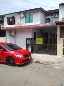 a red car parked in front of a house at khairul homestay taman tengiri seberang jaya in Kampong Telok