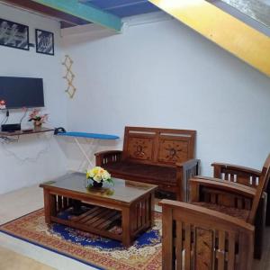 uma sala de estar com mobiliário em madeira e uma mesa em khairul homestay taman tengiri seberang jaya em Kampong Telok