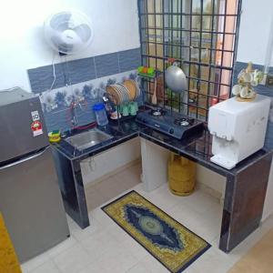 a kitchen with a counter with a sink and a refrigerator at khairul homestay taman tengiri seberang jaya in Kampong Telok