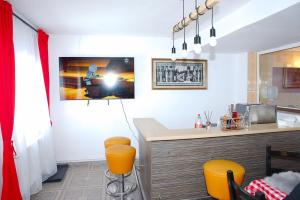 a kitchen with a bar with orange stools at Pensiunea Royal in Ranca +5 photos