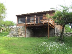 a house with a balcony on the side of it at Cabañas de Montaña San Miguel in Cortaderas