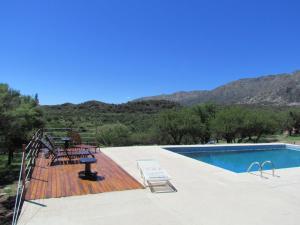 una piscina con sillas en una terraza de madera junto a en Cabañas de Montaña San Miguel en Cortaderas