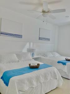 a bedroom with two beds and a ceiling fan at Hermoso apartamento en la playa in Cartagena de Indias