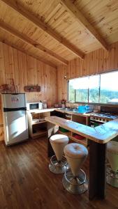 - une grande cuisine avec des murs en bois et un grand comptoir dans l'établissement Casa Atardecer Vichuquén, à Vichuquén