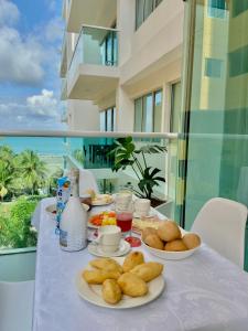 a table with plates of food on a table on a balcony at Hermoso apartamento en la playa in Cartagena de Indias