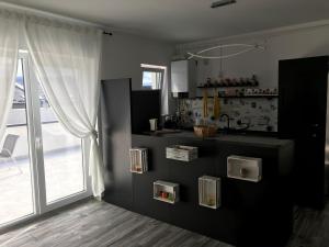 eine Küche mit Theke und großem Fenster in der Unterkunft Fok Flat Sibiu in Turnişor