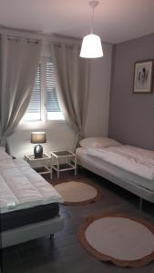 a bedroom with two beds and a window at Maison meublée de la Varenne in Pannes