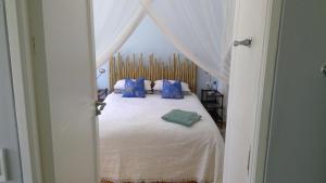 a bedroom with a bed with blue pillows at Little Farm in Raithby