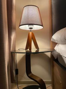 a lamp sitting on a glass table next to a bed at M25 Bakuriani in Bakuriani