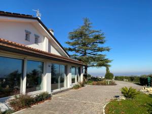 une maison avec un chemin à côté d'un arbre dans l'établissement Villa Fai Bei Sogni-Green Bed & Breakfast, à Coriano