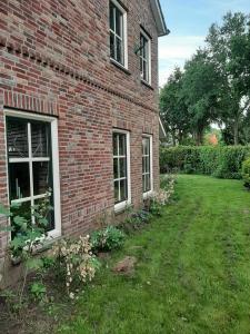 een stenen huis met een tuin naast een gebouw bij 'T Wolthoes in Vlagtwedde