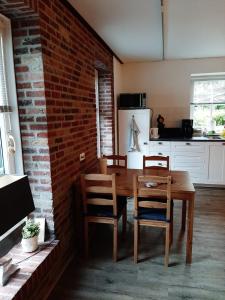 uma sala de jantar com uma mesa de madeira e cadeiras em 'T Wolthoes em Vlagtwedde