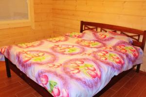 Una cama con flores rosas y amarillas. en SaimaanHelmi en Savonlinna