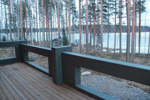 una terraza con vistas al lago y a los árboles en SaimaanHelmi en Savonlinna