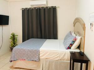 a bedroom with a bed with a black curtain at City Garden 2 Apartment in Belize City