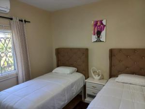 a bedroom with two beds and a window at Red Hassell Manor in Port Antonio