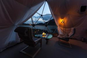 貝圖斯托的住宿－Jotunheimen Arctic Domes，帐篷内的房间,配有两把椅子和一张桌子