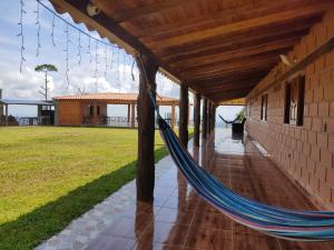 eine Hängematte auf der Veranda eines Hauses in der Unterkunft Finca campestre y recreativa los potrillos in Doradal
