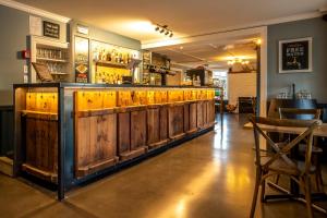 um bar com armários de madeira e uma cadeira de madeira em The Hurunui Hotel em Hurunui