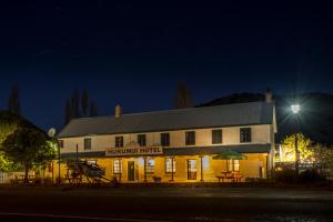 a large white building with a sign on it at night at The Hurunui Hotel in Hurunui