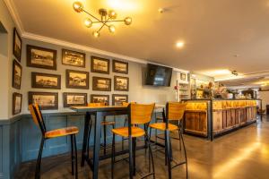 - un bar avec des tabourets orange dans un restaurant dans l'établissement The Hurunui Hotel, à Hurunui