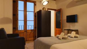 um quarto com uma cama, uma televisão e uma cadeira em Barrio Gotico Apartments Escudellers em Barcelona