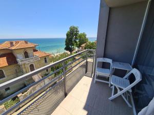 a balcony with two chairs and a view of the ocean at Hotel Mida in Obzor