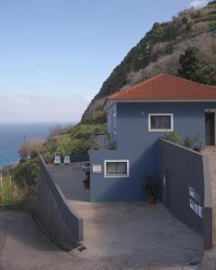 uma casa azul no lado de uma colina em Casa Azul - Ocean View em Porto Moniz