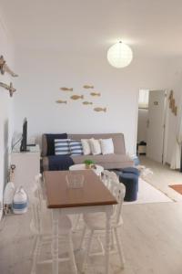 uma sala de estar com uma mesa e cadeiras e um sofá em Casa Azul - Ocean View em Porto Moniz