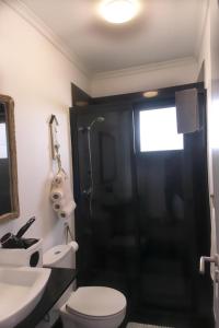 a bathroom with a shower and a toilet and a sink at Casa Azul - Ocean View in Porto Moniz