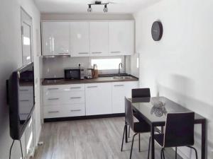 a kitchen with white cabinets and a table and chairs at Apartments Dora 2 in Bibinje