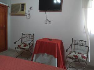 a room with a table and two chairs and a tv at Las orquídeas in Goya