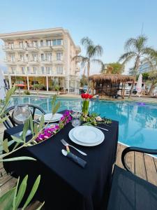 Poda Boutique Hotel Ksamil في كساميل: طاولة مع غطاء الطاولة السوداء بجوار حمام السباحة