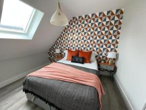 een slaapkamer met een groot bed met oranje kussens bij Beautifully Furnished 1 Bed Town Centre Apartment in Bournemouth