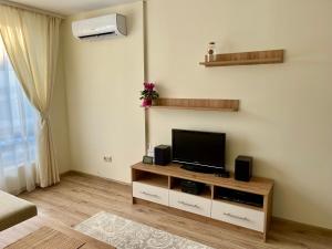 a living room with a flat screen tv on a cabinet at Pirin Dream View Apartments in Razlog