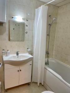 een badkamer met een wastafel, een douche en een bad bij Pirin Dream View Apartments in Razlog