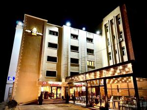 a building with lights in front of it at night at MBI Travel Inn in Craiova