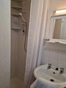 een badkamer met een wastafel en een douche met een spiegel bij Fern Villa in Blackpool